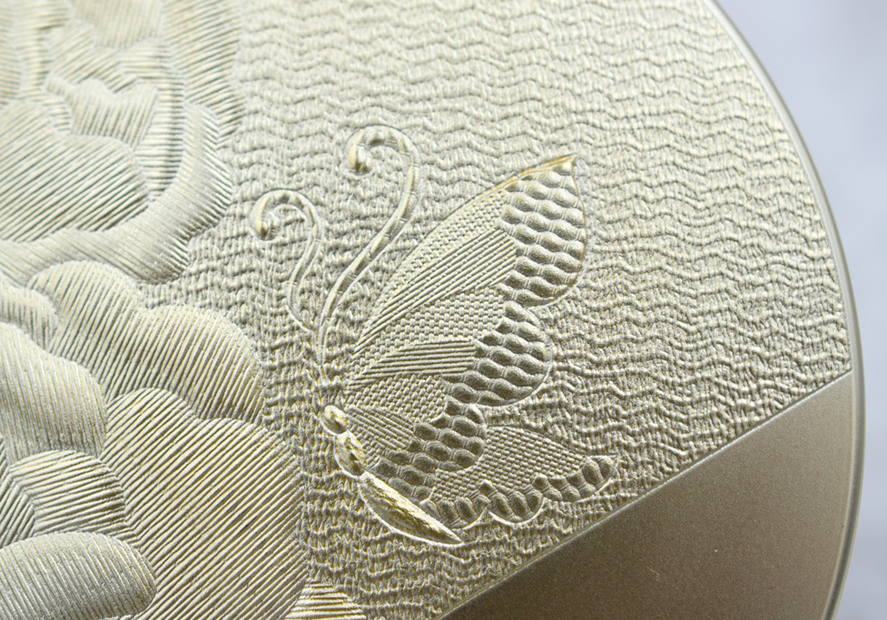 レーザー彫刻によって背景には、ちりめん布のテクスチャ手前の花と蝶には刺繍のようなテクスチャを加工した成形サンプル