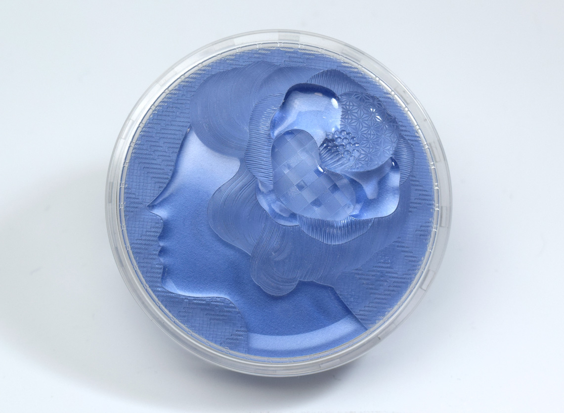 女性の横顔全体を切削彫刻で加工後、髪の毛や髪飾り、背景をレーザー彫刻で加工した成形サンプル