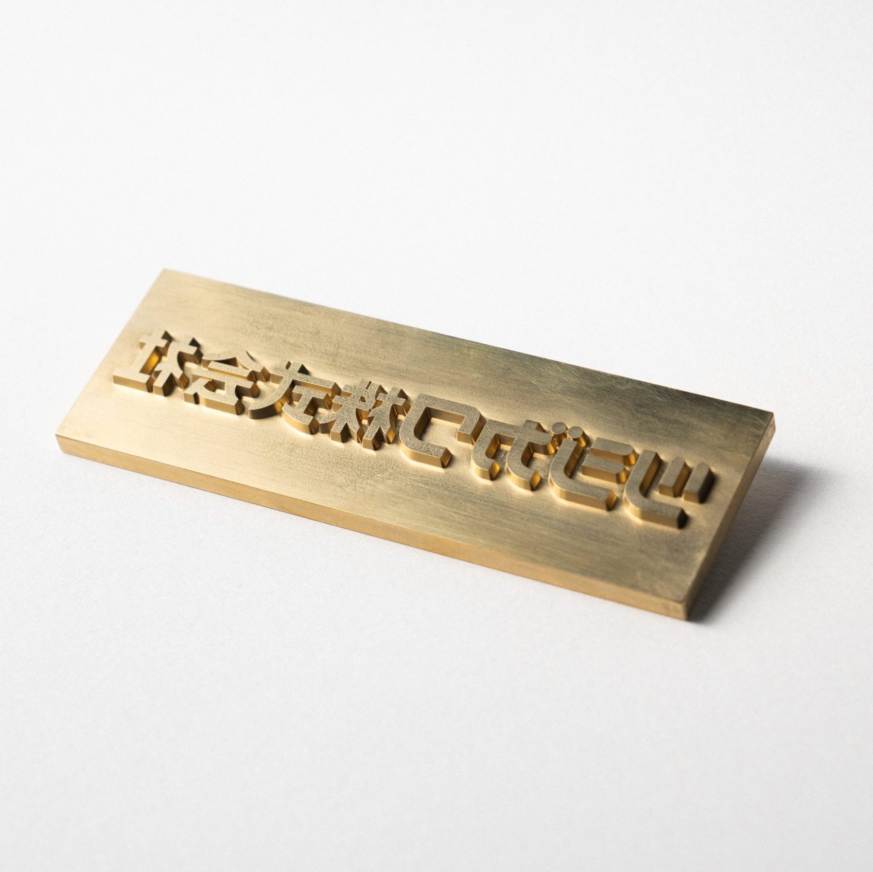 真鍮製平彫刻版画像 ツジカワ株式会社の文字が彫刻されている