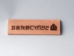 銅の箔版の写真。ツジカワ株式会社の文字が凸になっている。
